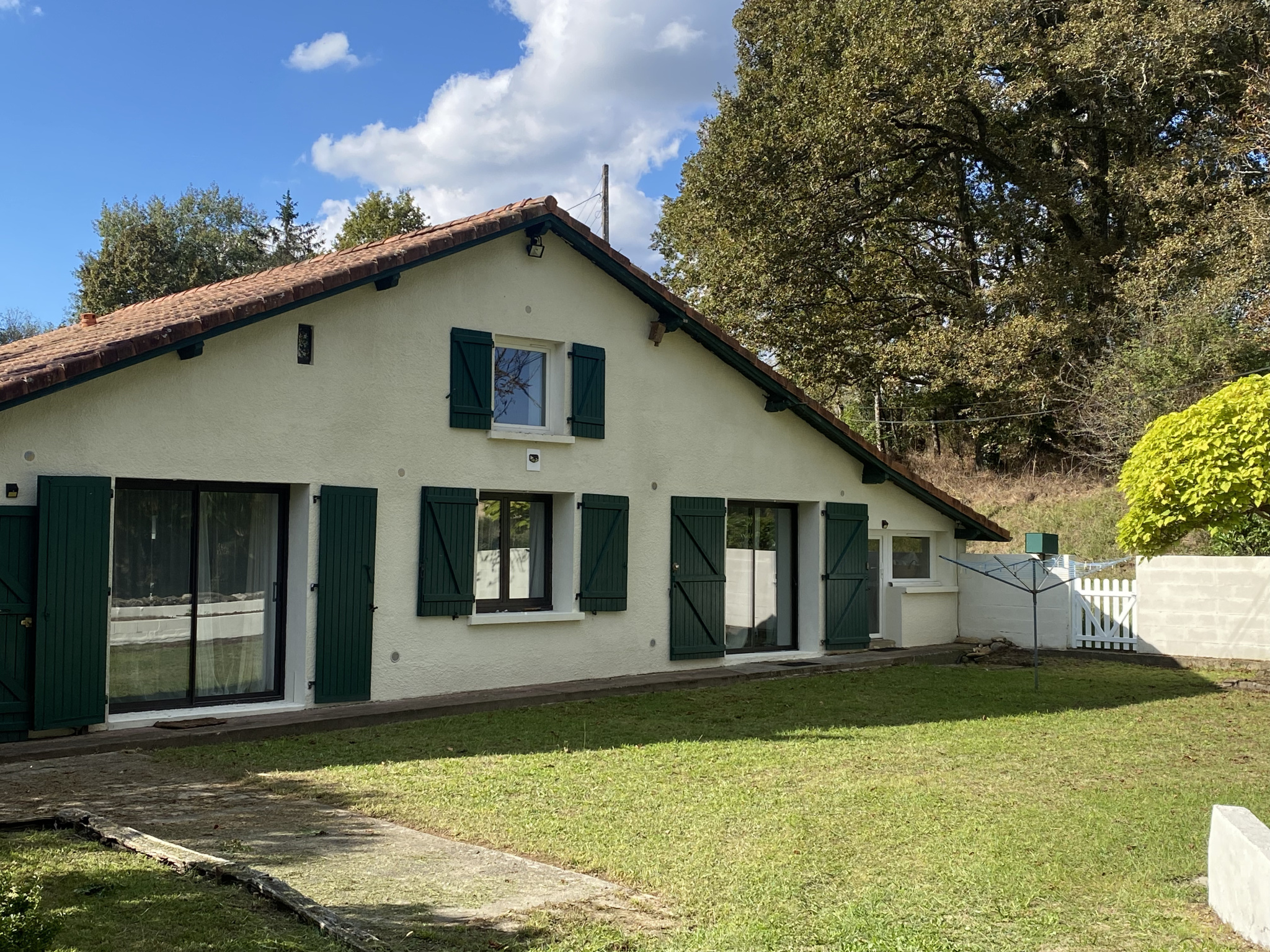 Maison à vendre à Dax : maison blanche avec volets verts et toit de tuiles